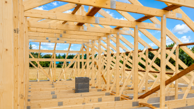 Wnętrze budynku z prefabrykowaną konstrukcją dachu z drewnianych wiązarów podczas realizacji strych 